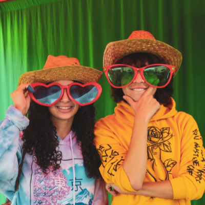 Two students with big heart sunglasses and straw hats
